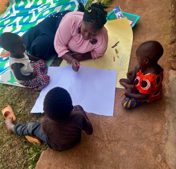 woman with three children drawing